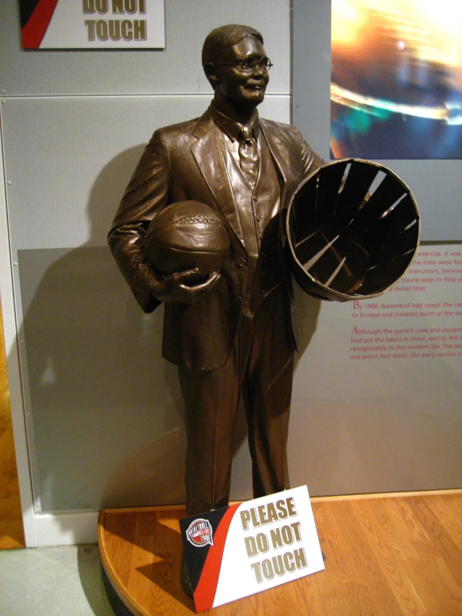 Statue of James Naismith holding a ball and peach basket at the Basketball Hall of Fame